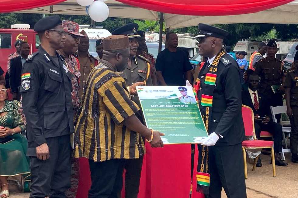 Regional Minister James Gunu presents citation to DCFO Joy Ameyibor Ayim